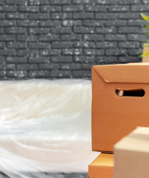 Moving in or moving out concept. Stack of boxes and packed furniture